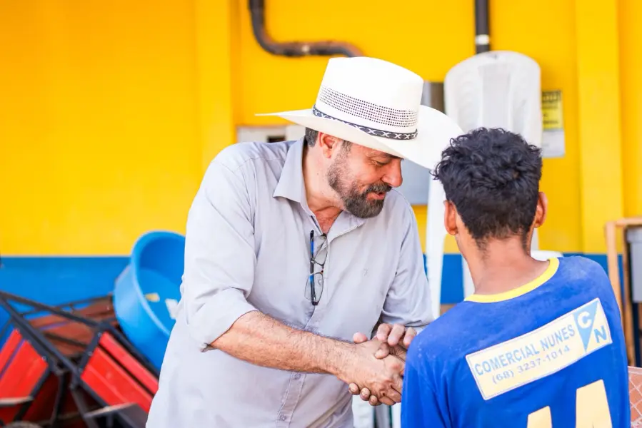 Júnior Betão cumprimentando um jovem trabalhador