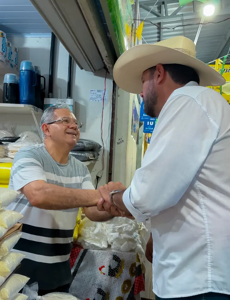 Júnior Betão cumprimentando um comerciante